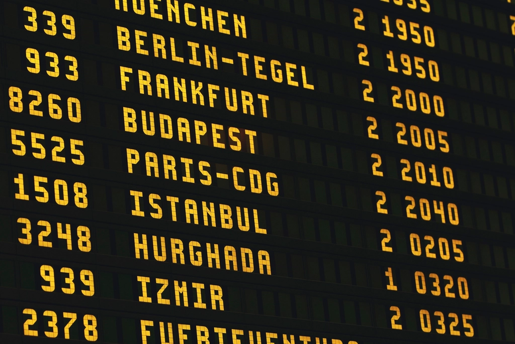 A large airport departures board listing international flights to cities in Europe, Asia and Latin America.