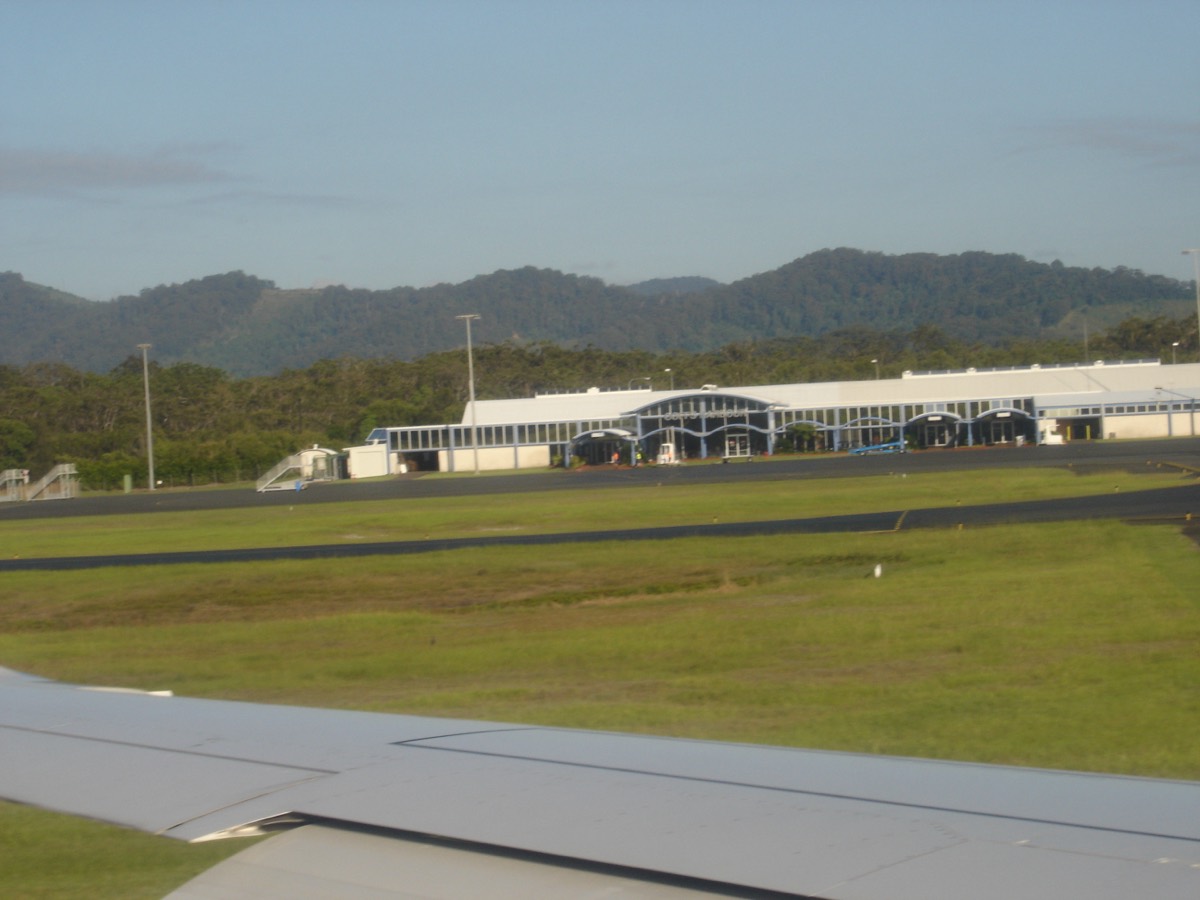 A passenger jet parked at an airport gate while ground crews prepare it for the next departure.