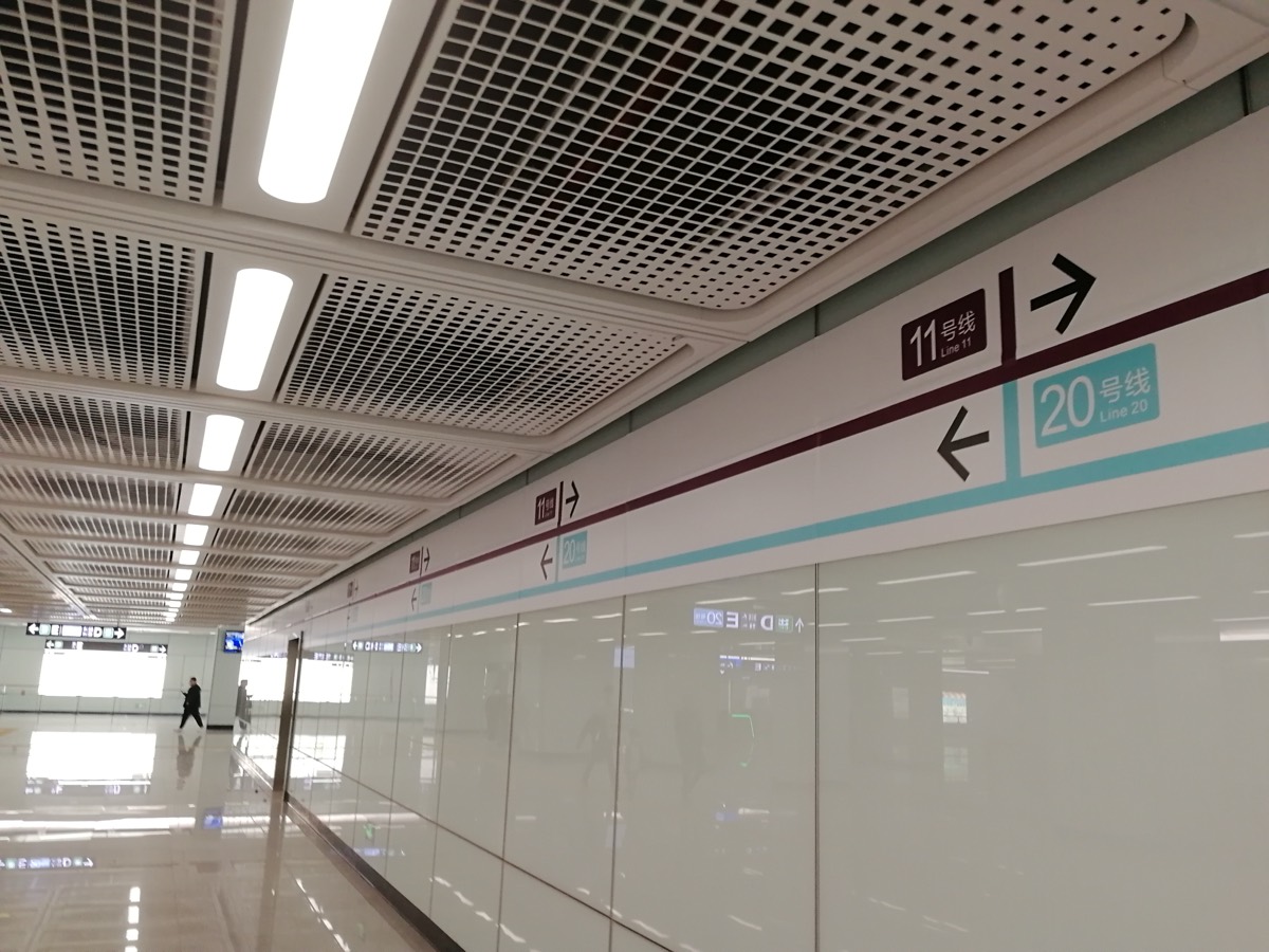 An overhead sign in an airport terminal directing connecting passengers toward flight transfers, away from the arrivals exit.
